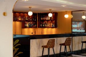 eine Bar mit drei Barhockern in einem Raum in der Unterkunft Platinum Hôtel Spa Abidjan Cocody in Abidjan