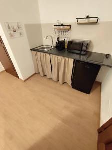 a kitchen with a sink and a counter with a microwave at La Dimora di Alma in Clivio
