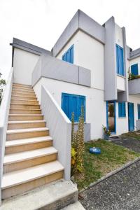 a white house with blue doors and stairs at Beach House Quiaios in Figueira da Foz