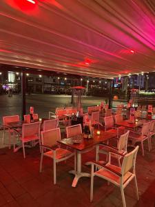 a restaurant with wooden tables and chairs and purple lighting at Hotel Cataleya in Almere