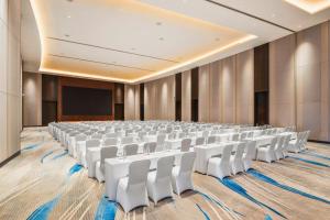 an empty conference room with white chairs and a screen at Amari Vientiane in Vientiane
