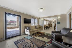 a living room with a couch and a tv at Best Western Caprock Inn in Brownfield
