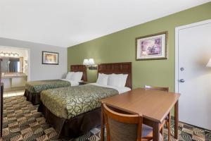 a hotel room with two beds and a table at Best Western Caprock Inn in Brownfield