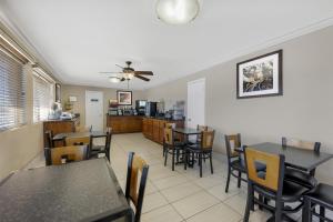 a dining room with tables and chairs and a kitchen at Best Western Caprock Inn in Brownfield