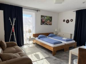 a bedroom with a bed and a couch at Pension Genat in Wedemark