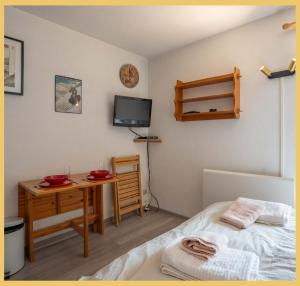 a bedroom with a bed and a desk and a tv at Chez Candide I Studio I Montriond in Montriond +15 photos