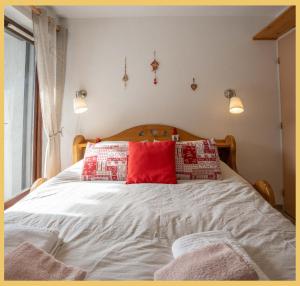 a bedroom with a large bed with a red pillow at Chez Candide I Studio I Montriond in Montriond