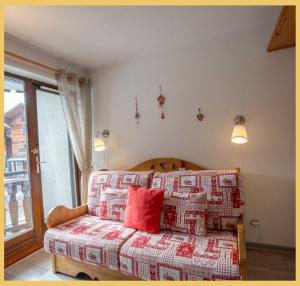 a bedroom with a bed with a red pillow at Chez Candide I Studio I Montriond in Montriond