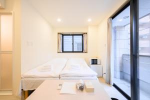 a small room with two beds and a table at Oku Apartment in Tokyo