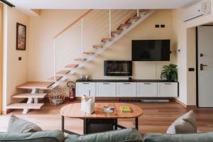 a living room with a staircase and a tv at Tims Vista Bella - Mezzegra, Tremezzina by LoveComo in Lenno