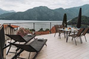 a patio with a table and chairs on a balcony at Tims Vista Bella - Mezzegra, Tremezzina by LoveComo in Lenno