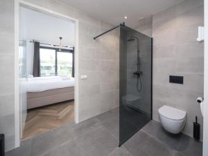 a bathroom with a shower and a toilet at Harderwold Villa - 551 in Zeewolde +19 photos