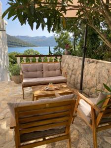 a patio with a couch and chairs under an umbrella at Apartment MiriMore in Hodilje