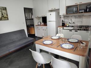 a kitchen with a table with plates and wine glasses at Piemonte Flat Serra Negra in Serra Negra