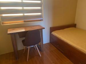 a small bedroom with a desk and a bed at Balai Moca Hillside with Sunset View in San Juan