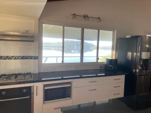 a kitchen with a refrigerator and a stove top oven at Salt and Sea-renity in Russell Island