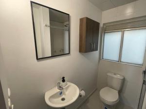 a bathroom with a sink and a toilet and a mirror at Casa Bachué Hotel Boutique in Chía +49 photos