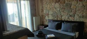 a bedroom with a bed and a stone wall at Villa Paliouri in Paliouri