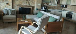 a living room with a couch and a table at Villa Paliouri in Paliouri +4 photos