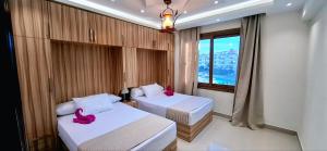 two beds in a room with two pink flamingos on them at Sharm Hills Azure Paradise in Sharm El Sheikh +234 photos