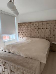 a large bed with a padded headboard in a bedroom at La Priva House in Charleroi