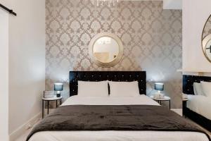 a bedroom with a large bed and a mirror at Hobart Retreats - Sanctuary and Haven in Hobart