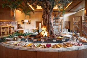 a table filled with different types of food in front of a tree at The St. Regis Cap Cana Resort in Punta Cana