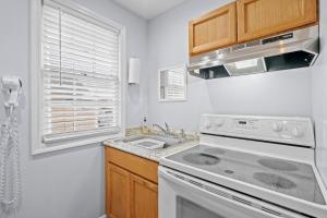 a white kitchen with a stove and a sink at Vitamin Sea Suites 3 in Carolina Beach