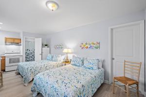 a bedroom with two beds and a table and a chair at Vitamin Sea Suites 3 in Carolina Beach