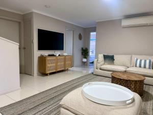 a living room with a couch and a tv at Aldinga Beach Reef Escape in Aldinga Beach