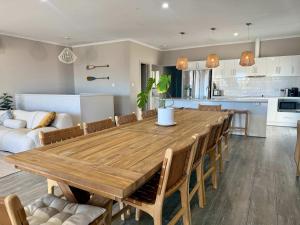 a dining room and kitchen with a wooden table and chairs at Aldinga Beach Reef Escape in Aldinga Beach