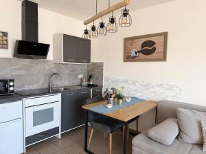 a kitchen and living room with a table and a couch at Pension Genat in Wedemark