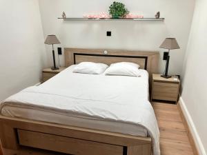 ein Schlafzimmer mit einem Bett mit zwei Lampen und einem Regal in der Unterkunft Galantou in Monflanquin + 31 Fotos