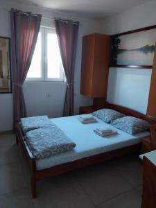 a bedroom with a bed and a window at LIBERO APARTMANI in Surčin