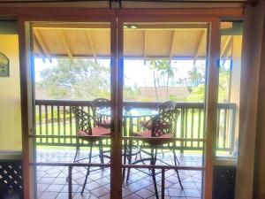 a patio with a table and chairs on a balcony at Molokai Kepuhi Beach Gem in Kepuhi