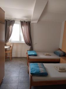 a dorm room with three beds and a window at LIBERO APARTMANI in Surčin