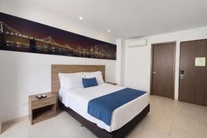 a bedroom with a bed and a painting of a bridge at Torca Hotel in Cali
