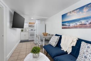 a living room with a blue couch and a kitchen at Vitamin Sea Suites 2 in Carolina Beach