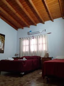 ein Schlafzimmer mit zwei Betten und einem Fenster in der Unterkunft HOTEL y EXCURSIONES TEJADA in Fiambala
