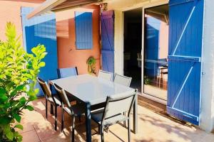 a white table and chairs on a patio at Maisonnette Les Coraux residence prive avec piscine in Canet-en-Roussillon