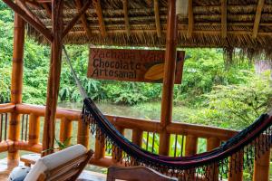 a hammock on a porch with a sign on it at Coati Lodge Misahualli in Tena