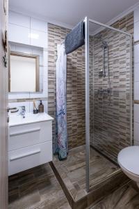a bathroom with a shower and a sink at Mirabella apartman in Csopak +17 photos