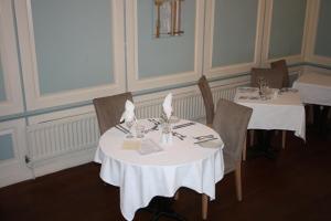 a dining room with two tables with white table cloth at East Cliff Cottage Hotel in Bournemouth