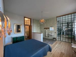 a bedroom with a blue bed and a bathroom at Hydra - Gutshaus Bückling in Rambin