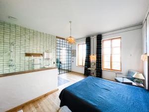 a bedroom with a blue bed and a bathroom at Hydra - Gutshaus Bückling in Rambin
