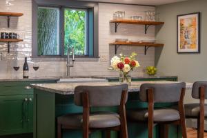 a kitchen with green cabinets and a counter with stools at La Tourelle Inn & Spa in Ithaca