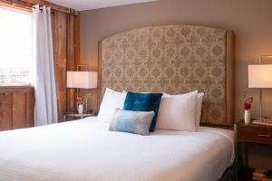 a bedroom with a large bed with a large headboard at La Tourelle Inn & Spa in Ithaca +104 photos
