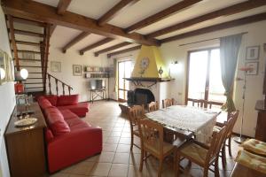 a living room with a red couch and a table at Villa Cassiani in Fiorenzuola di Focara