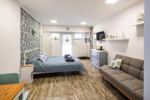a bedroom with a bed and a couch at Mirabella apartman in Csopak