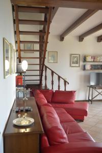 a red couch in a living room with a staircase at Villa Cassiani in Fiorenzuola di Focara